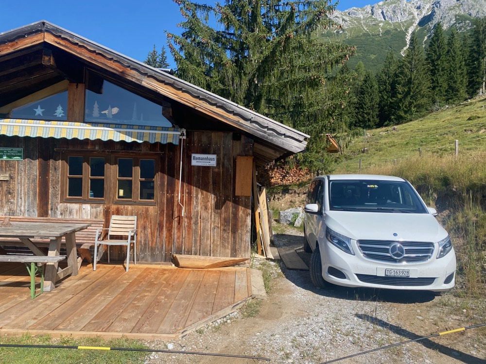 Die Hütte mit ihrem Holzbalkon an einem Sommertag