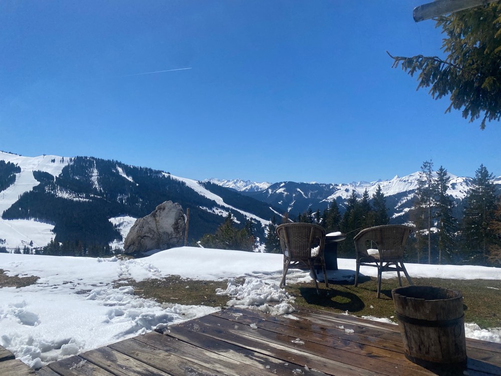 Blick von der verschneiten Alm über das Tal zu den Bergen