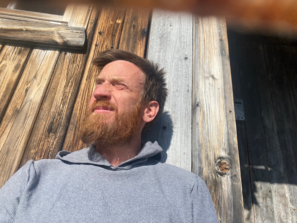 Ausruhen in der Sonne an der Holzwand der Hütte